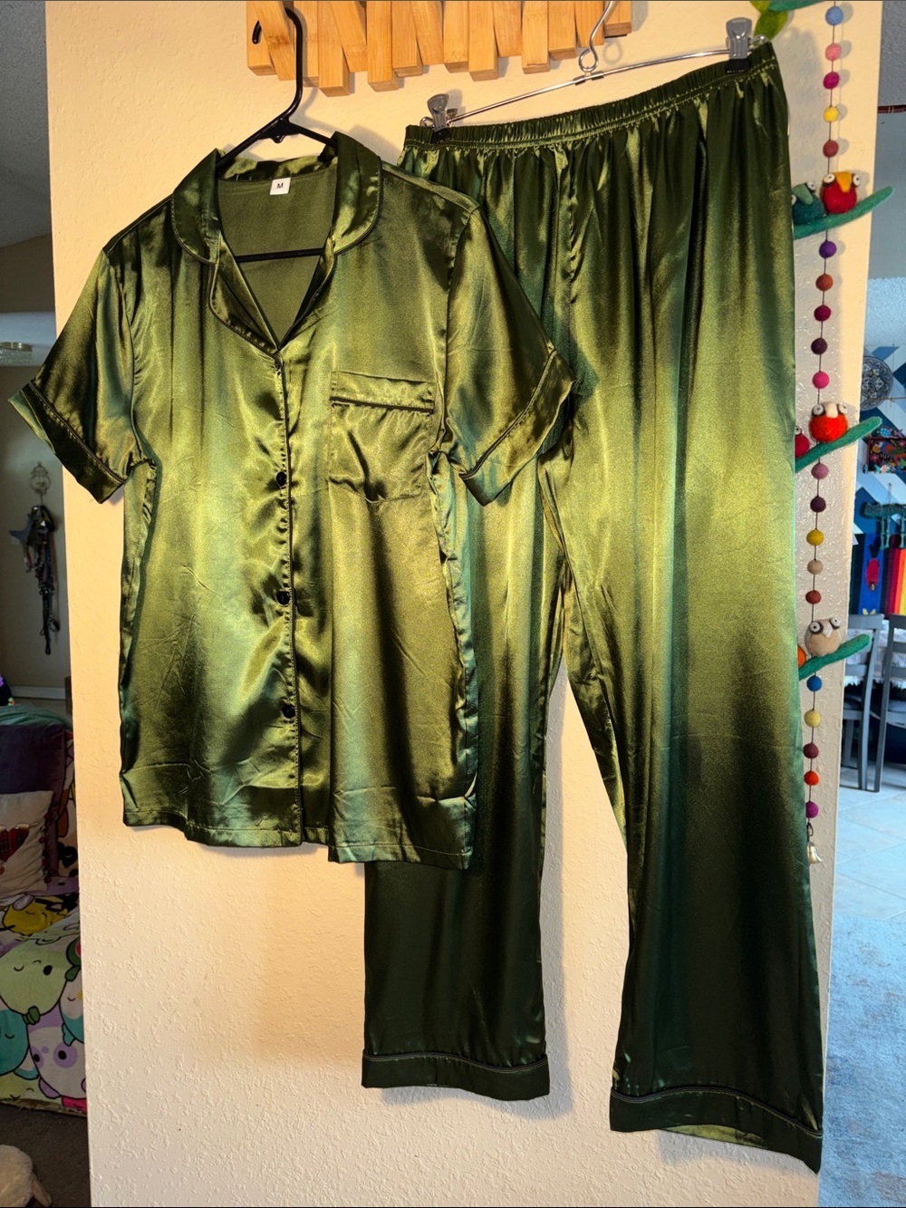 NWOT two-piece olive green satin pajama set. It features a short-sleeve button